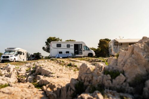 Campers geparkeerd op een mooie camping aan de kust met uitzicht op de zee, ideaal voor zomervakantie 2026.